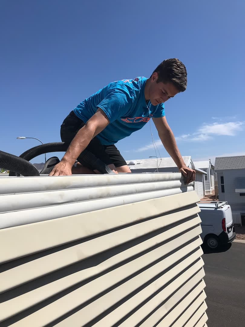 Gutter cleaning in progress — professional crew at residential eaves, Arizona
