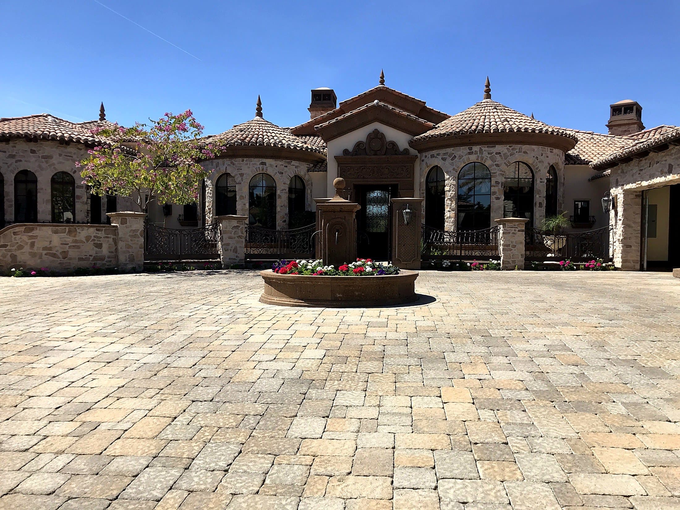 Stone estate with arched windows and courtyard fountain after exterior window cleaning — East Valley, Arizona
