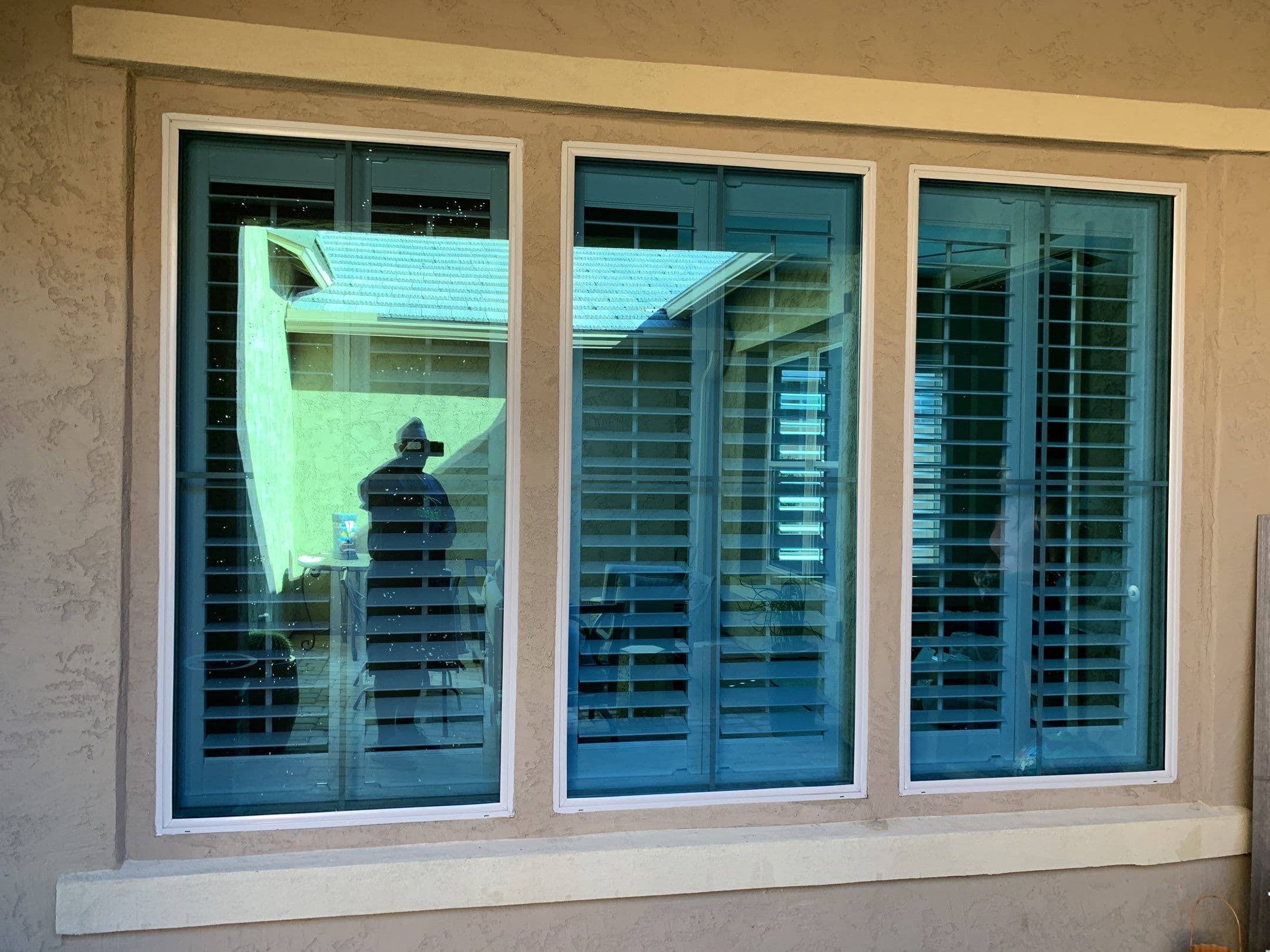 Three side-by-side windows with clear glass reflecting sky — Eastmark home exterior