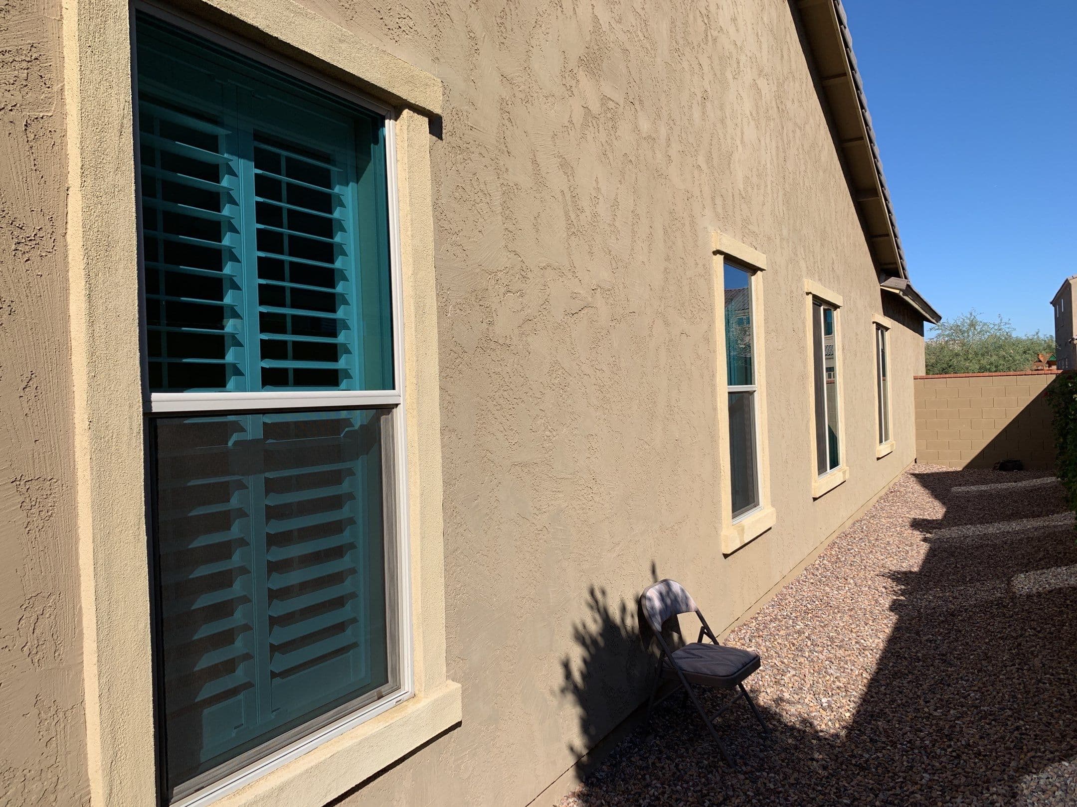 Row of residential windows with sunscreens along a tan stucco wall — Eastmark, Mesa